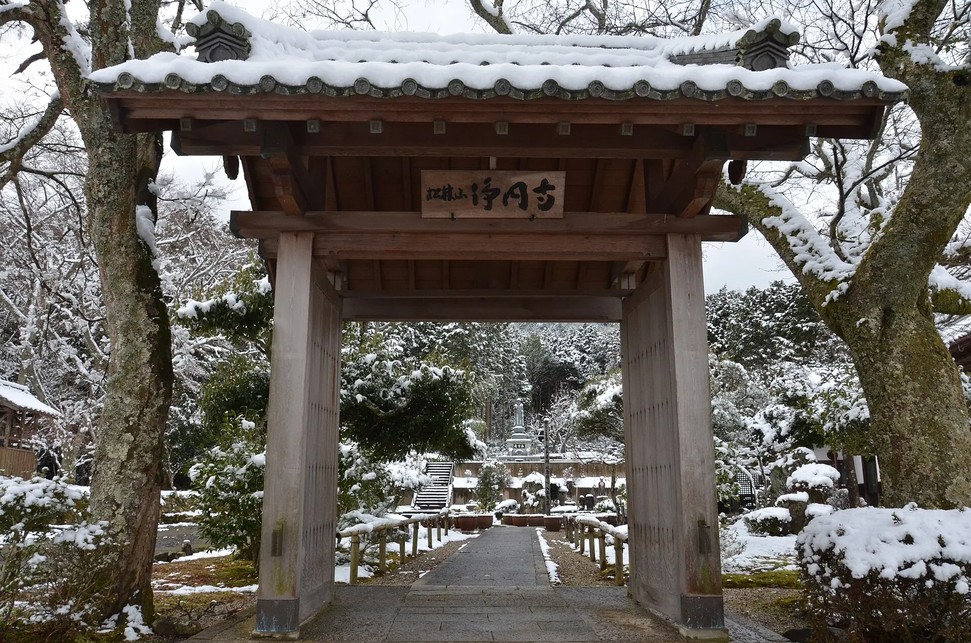 雪をかぶった浄円寺の山門と参道（兵庫県丹波市）